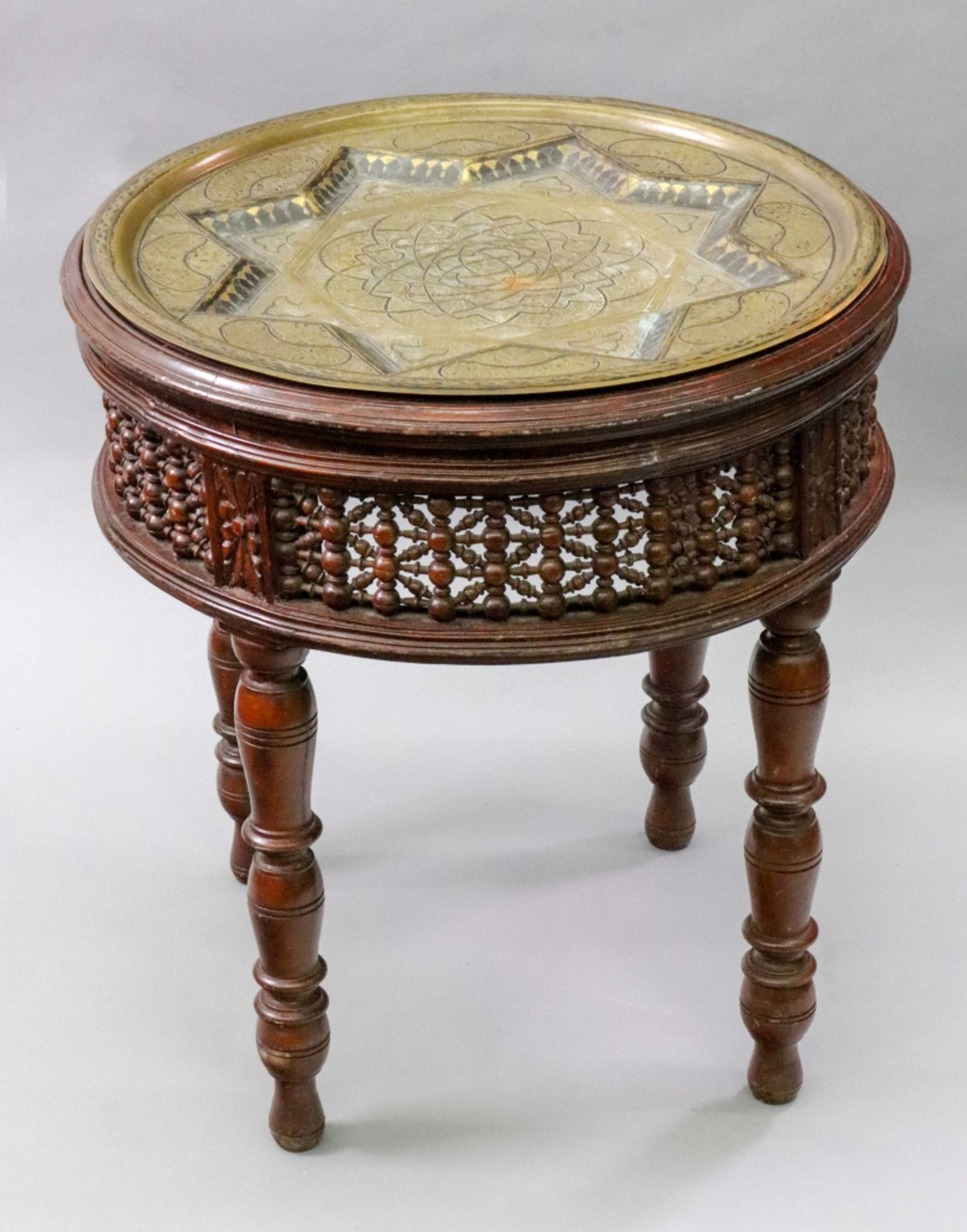 An Indo Persian mahogany circular stand, with a spindle filled frieze, on four ring turned legs,