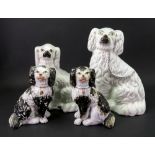 A large Staffordshire pottery Spaniel in white, late 19th century, 25cm high, another similar,