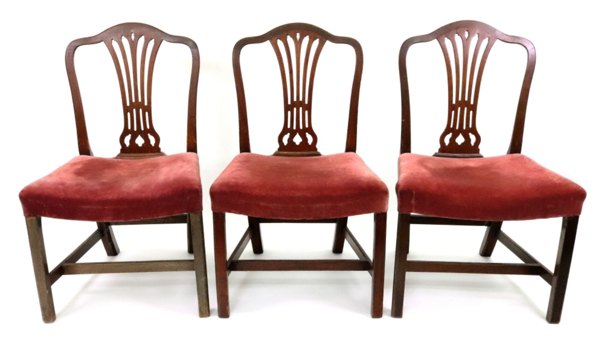 A set of three George III Hepplewhite style mahogany dining chairs,