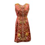 A handmade silk dress, with a floral design on a deep orange ground,