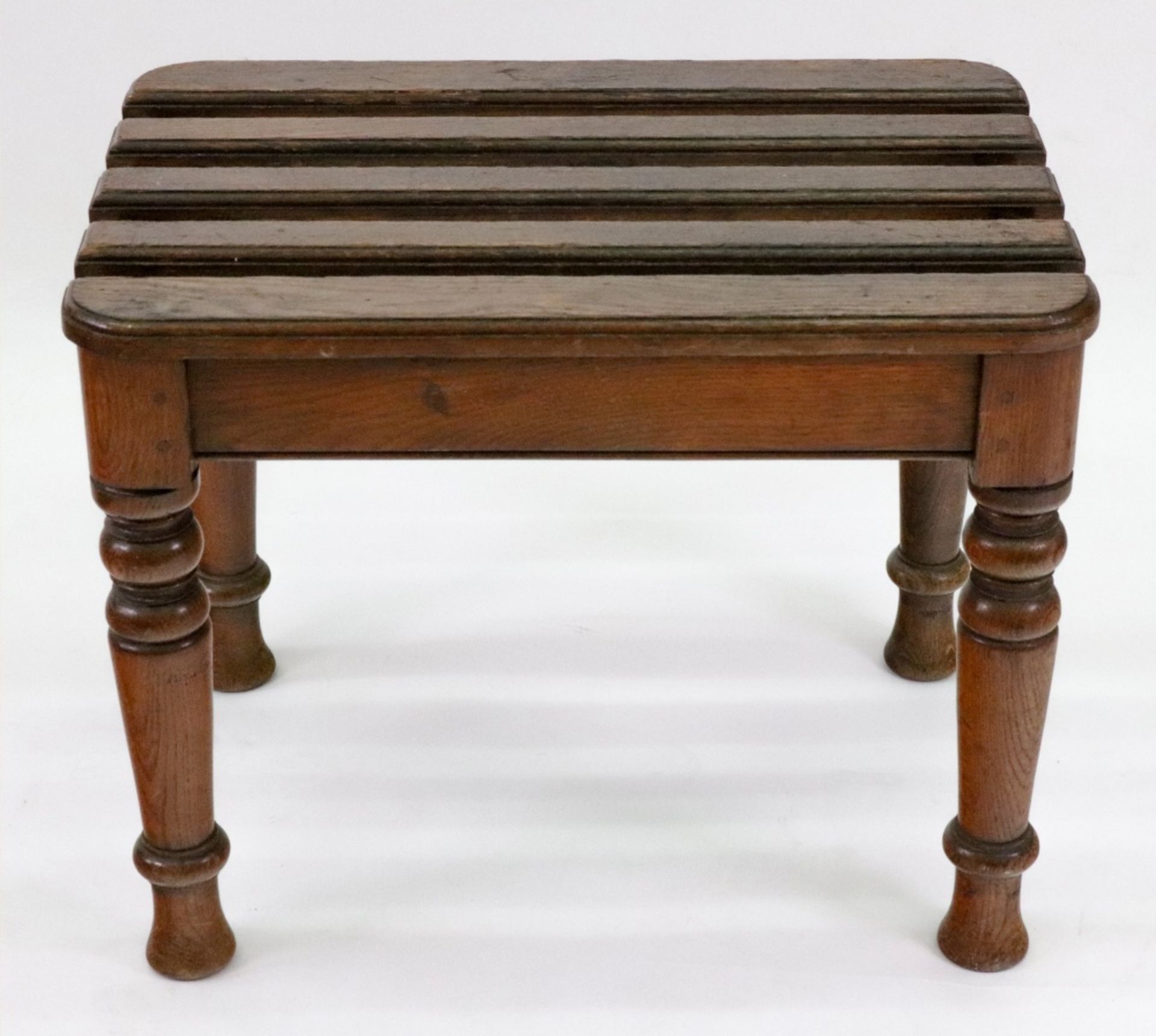 A late Victorian oak luggage rack, the slatted rectangular top on ring turned legs, 57.
