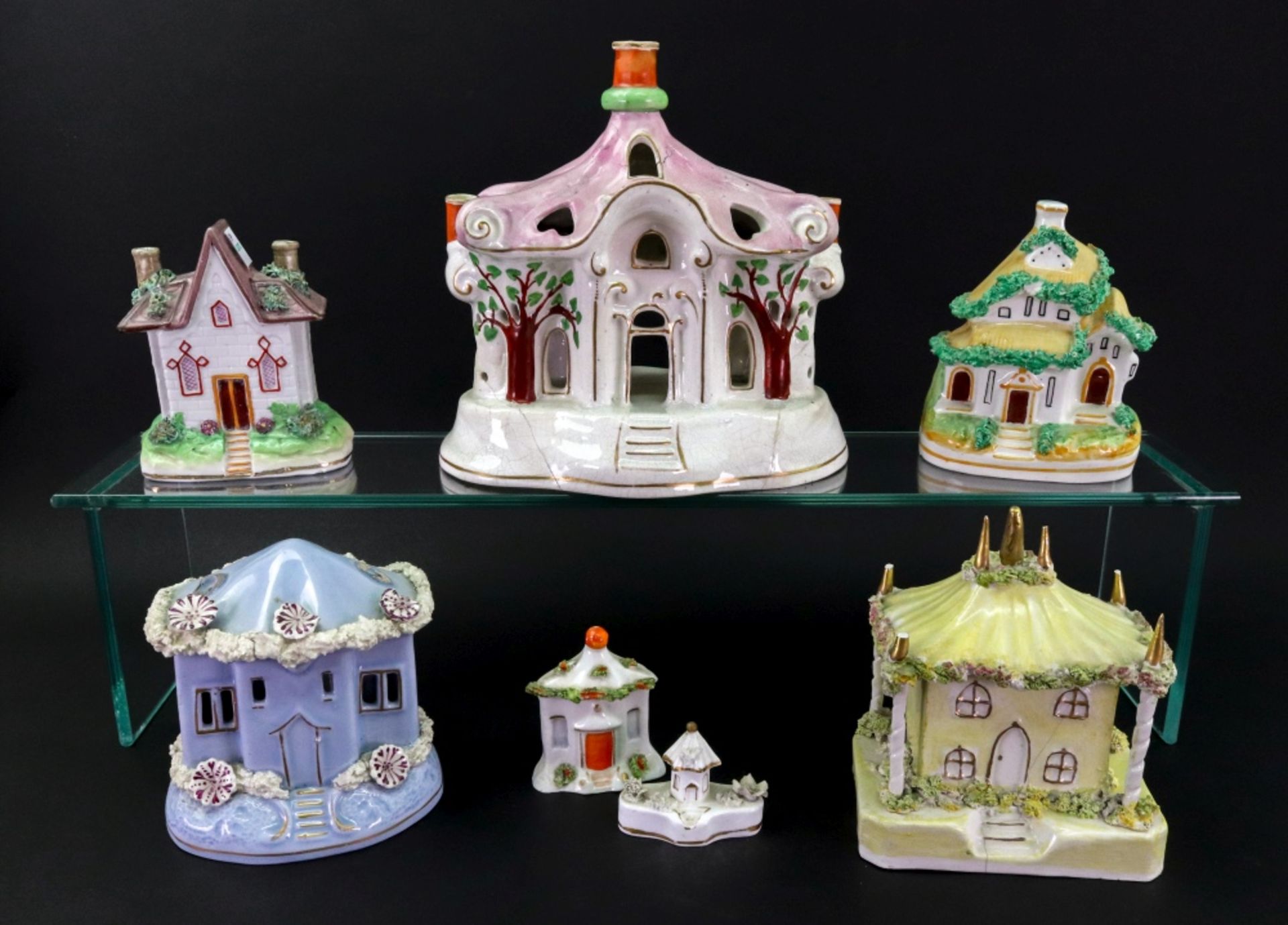 A group of six Staffordshire porcelain and pottery pastille burners and cottages,