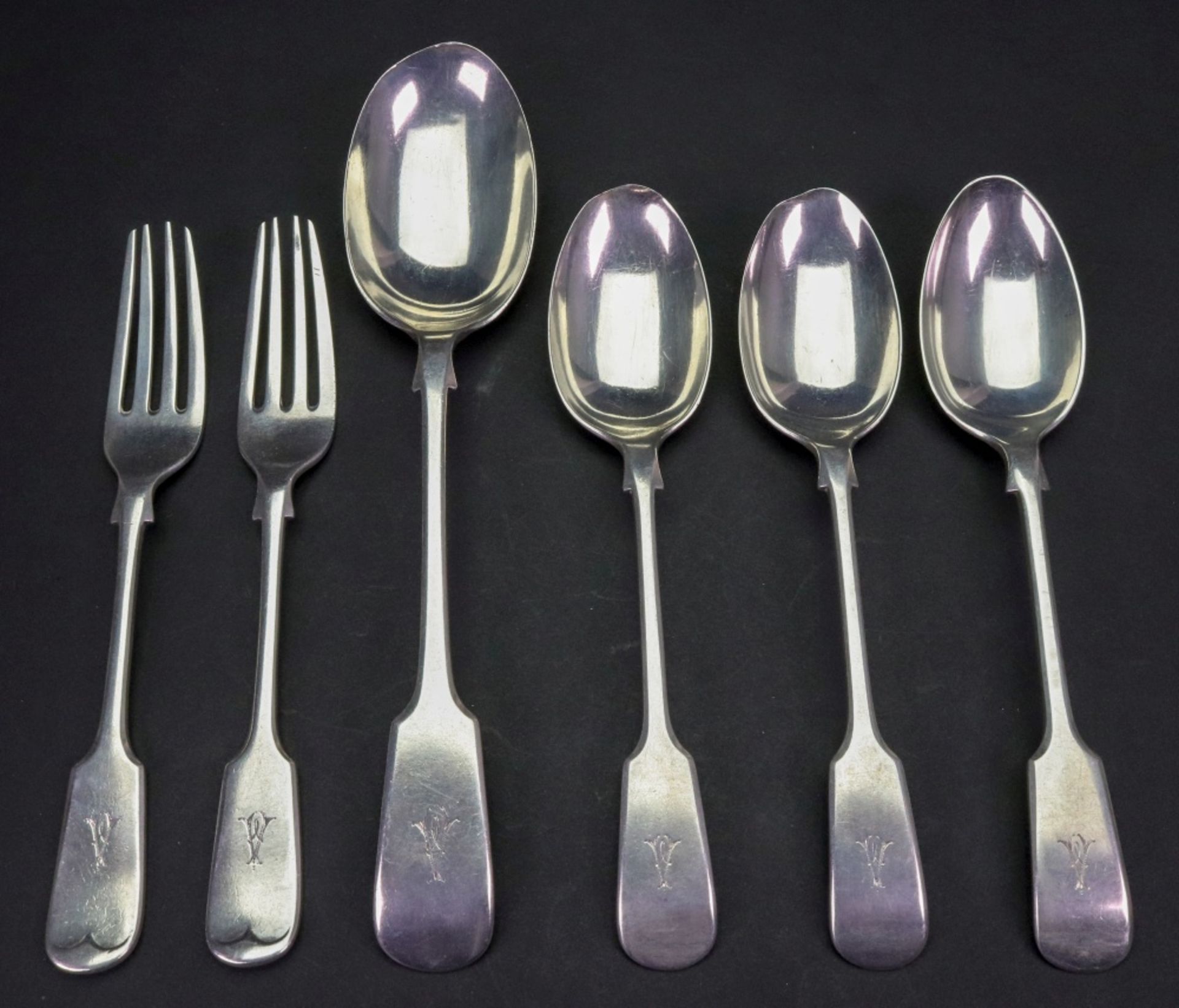 Three Edwardian fiddle pattern silver dessert spoons, two dessert forks and a tablespoon,