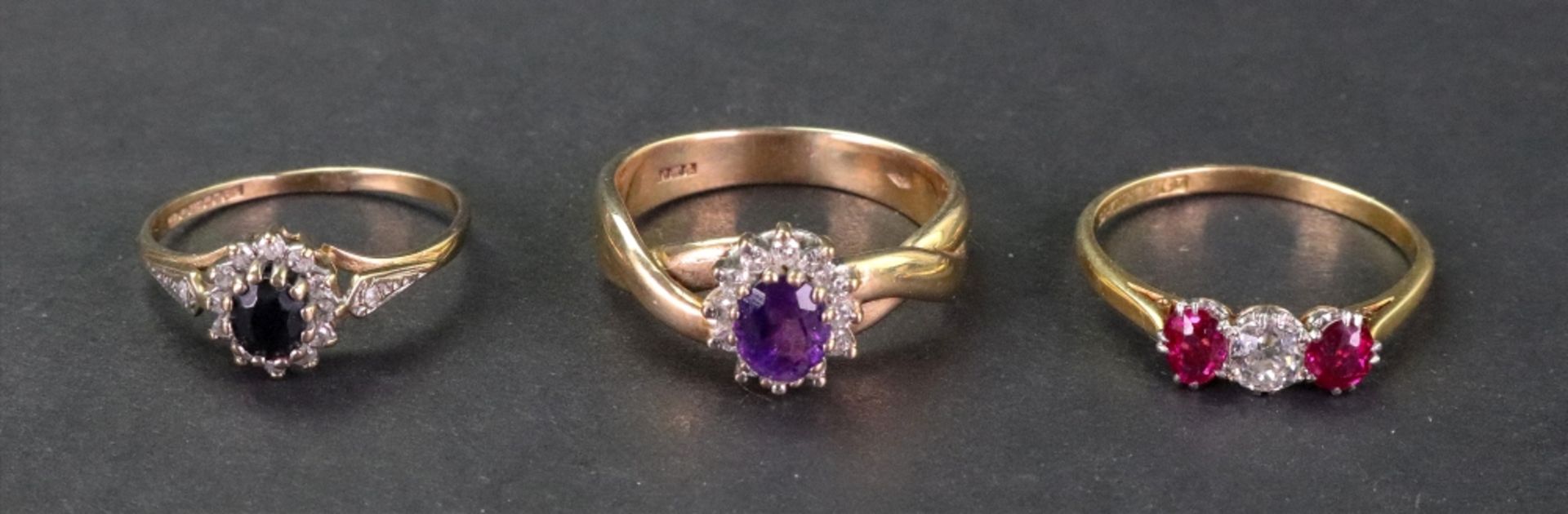 A gold, diamond and pink gemset three stone ring,