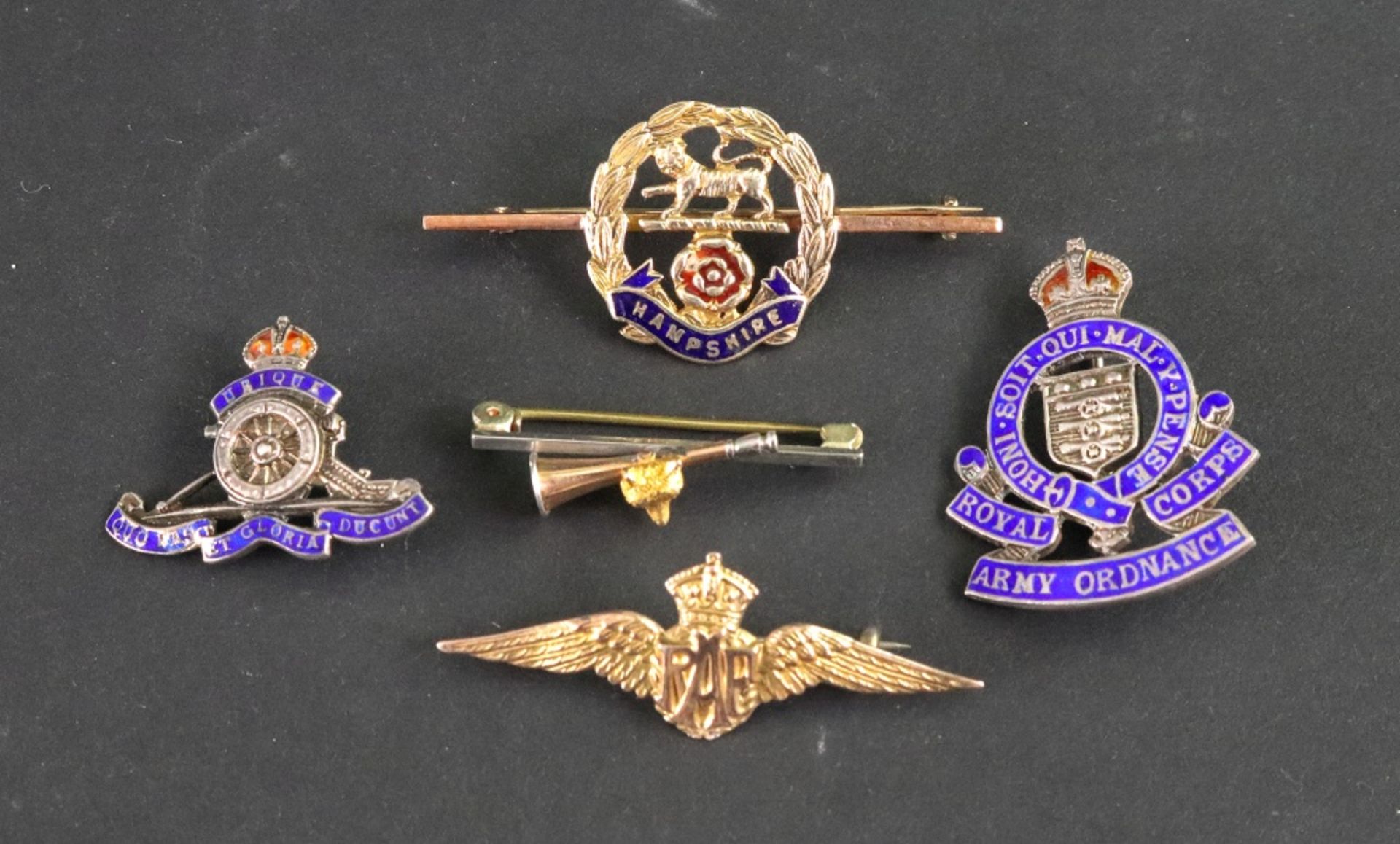 A collection of mostly military badges, including a gold RAF winged badge,