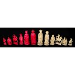 A Chinese carved ivory chess set, 19th century, one half stained red, the other natural, Kings 10.