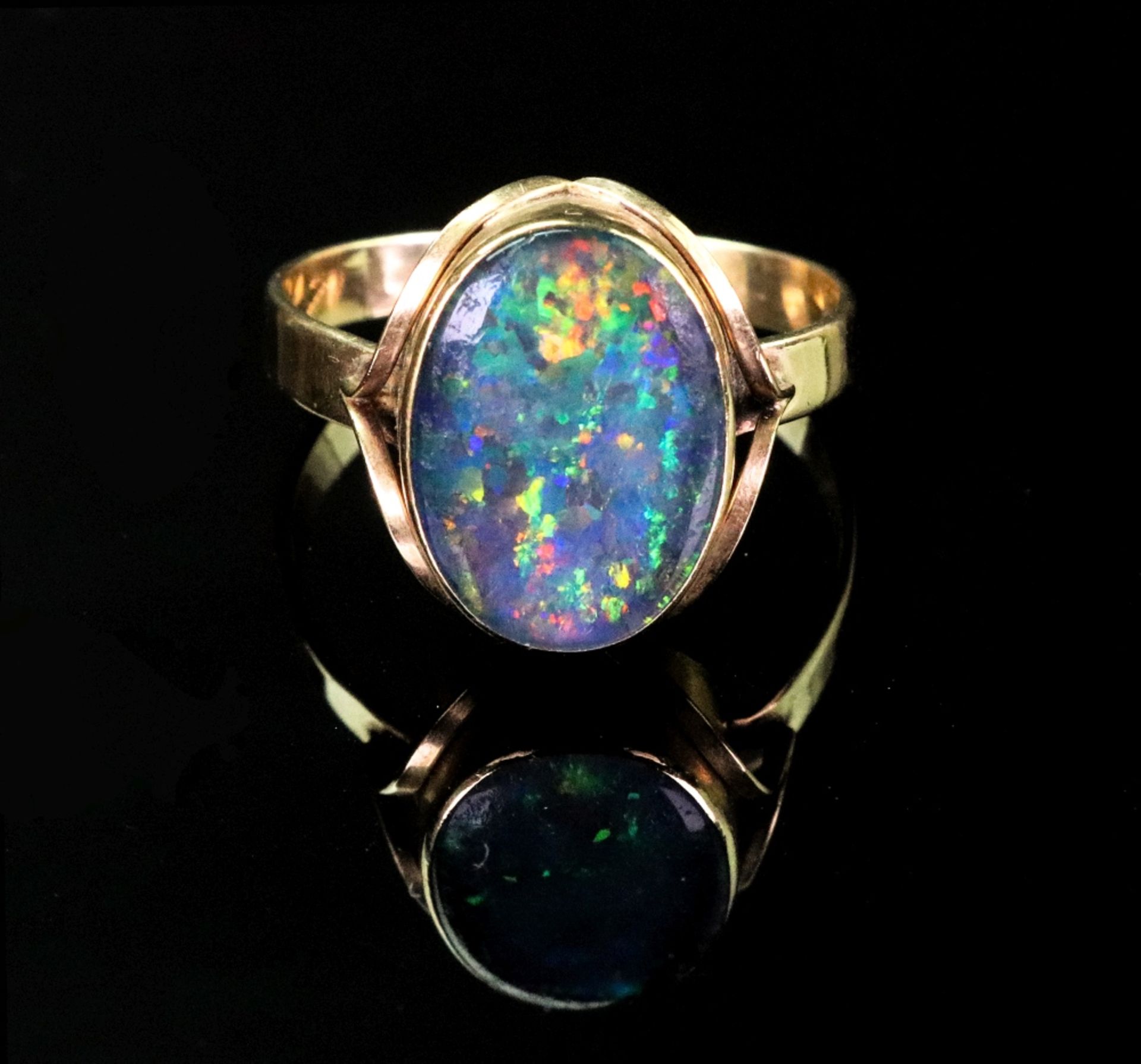 A gold and opal ring, the oval opal rubover set to gold band, ring size T, 3.15g gross.