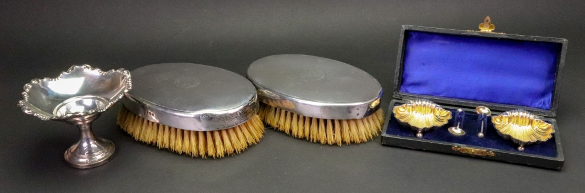 A pair of oval engine turned silver military hair brushes, London 1925, monogrammed,