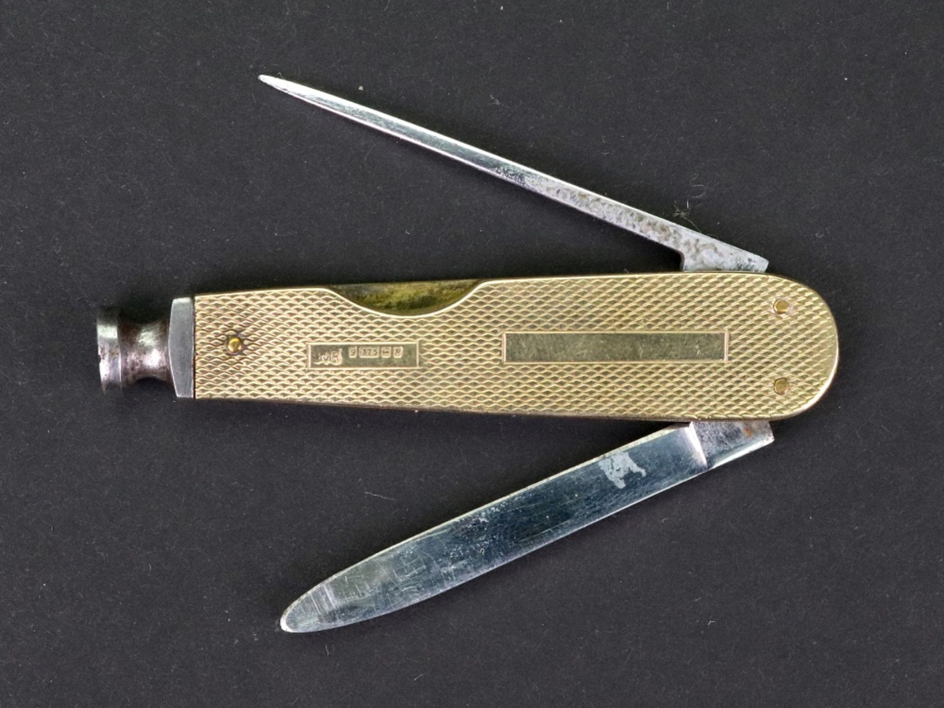 A 9ct gold mounted steel penknife, Birmingham 1964, engine turned with vacant cartouche, 7cm long.