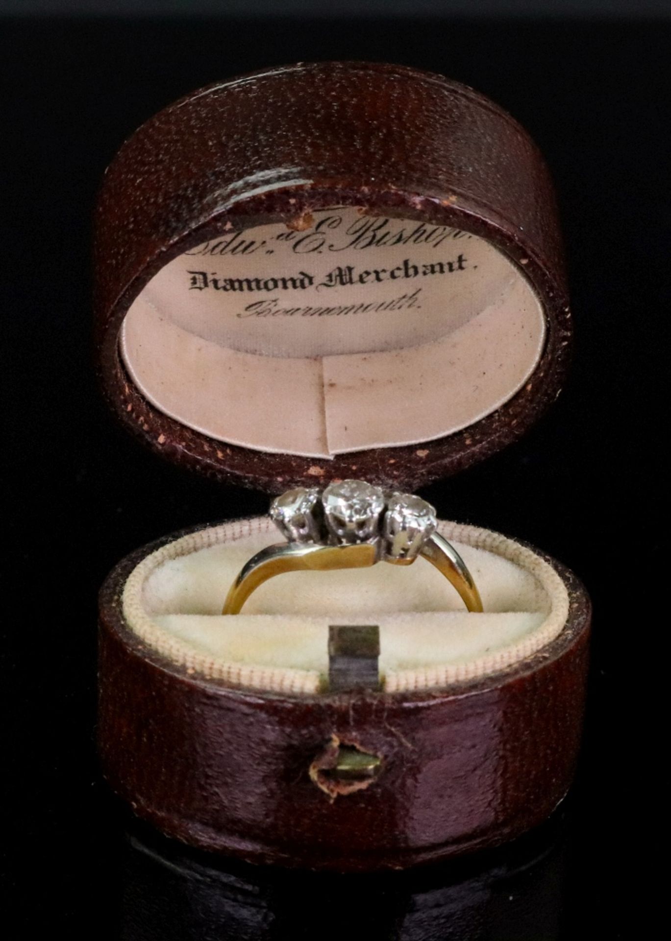 A gold and diamond three stone twist ring, the central round diamond weighs approximately 0.