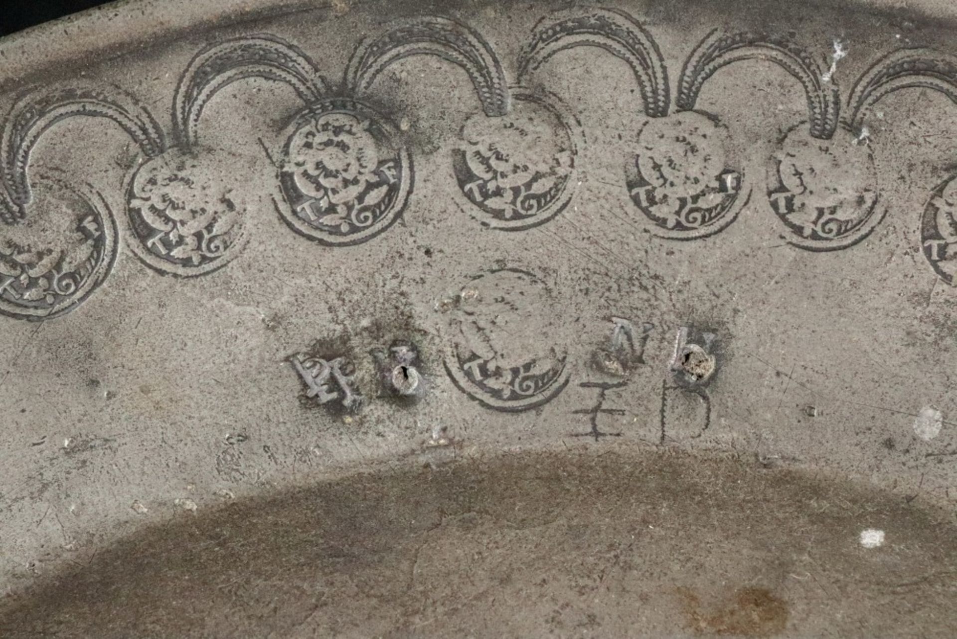 A broad rimmed pewter charger, 17th century, with punched arcading linked by repeated makers mark T. - Bild 2 aus 7