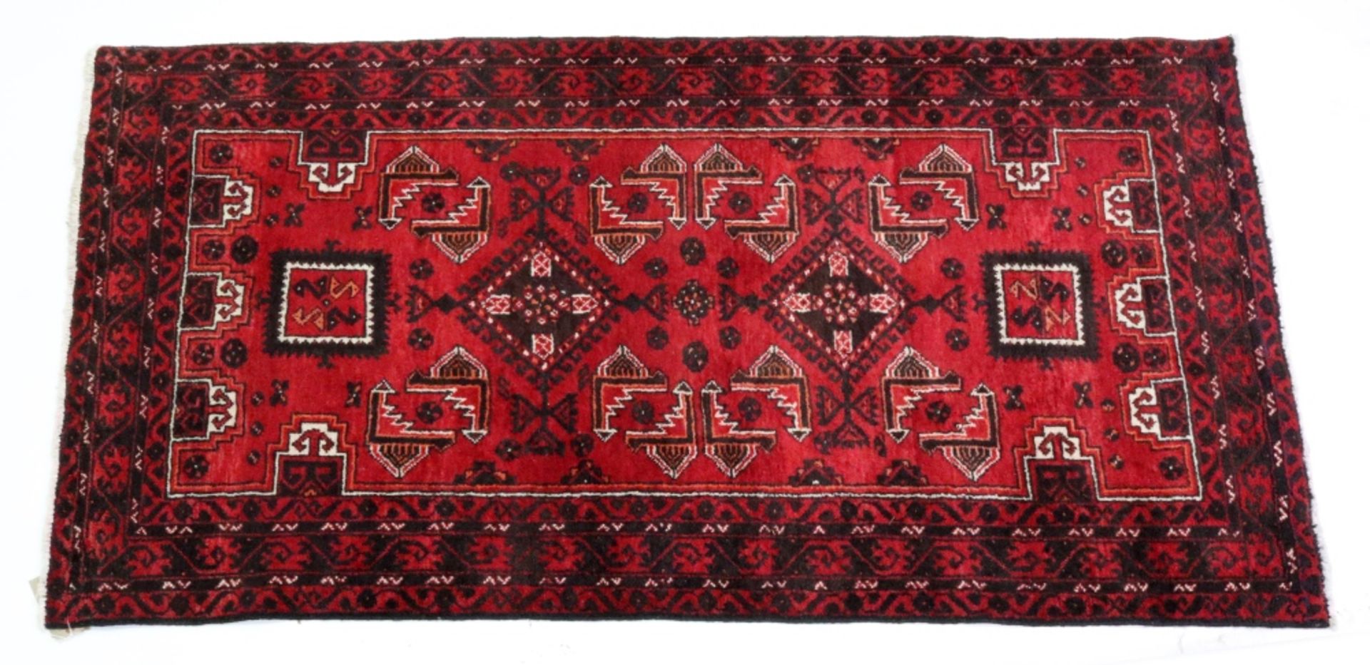 A Belochistan rug, the red field with a central lozenge medallion, 205 x 114cm.