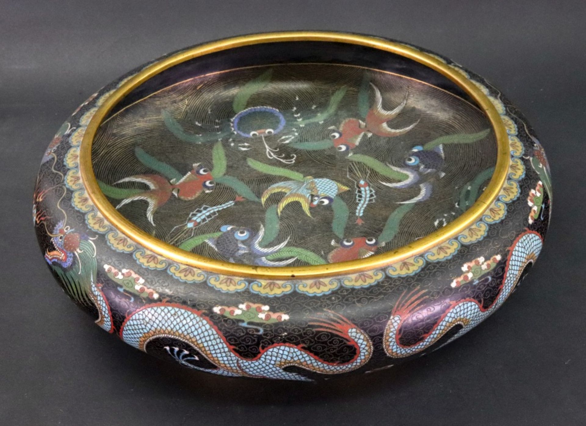 A Chinese cloisonne black ground bowl, circa 1900, of shallow circular form,