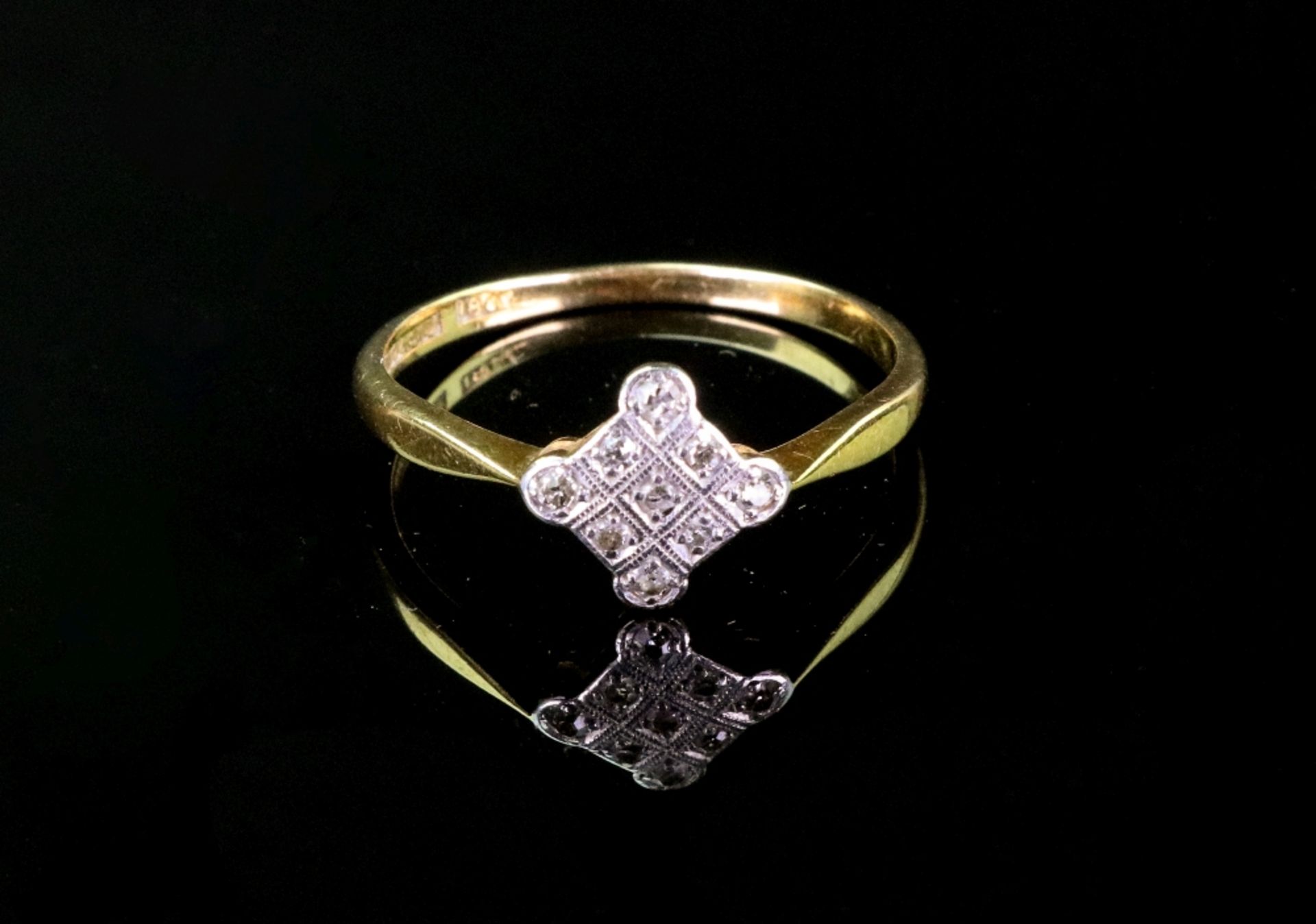 A gold and diamond ring, the white square panel set with old cut diamonds to gold band,