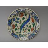 An Iznik pottery dish, early 17th century ,painted with tulips, roses and a saz leaf,