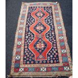 A Kazakh rug, Caucasian, the shaped madder field with three medallions,