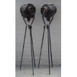 A pair of ebonised metal studio lights, circa 1950, each raised on a later metal tripod base.