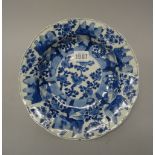 A Chinese blue and white moulded soup plate, Kangxi, painted in the centre with flowering prunus,