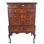 An early 18th century and later walnut crossbanded chest on stand with two short and three long