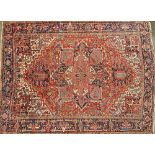 An Heriz carpet, Persian, the madder field with a bold medallion matching spandrels,