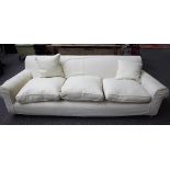 A modern three seat sofa, with cream loose covers, on turned beech supports, 225cm wide x 70cm high.