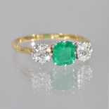 A gold, emerald and diamond set three stone ring,