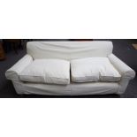 A modern three seat sofa, with cream loose covers, on turned beech supports, 210cm wide x 70cm high.