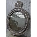 A 20th century white metal mirror with cartouche crest over circular embossed frame,