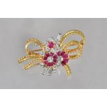 A gold ruby and diamond brooch, designed as a floral and ropetwist wirework spray,