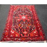 A Hamadan rug, Persian, the black field with a madder medallion, spandrels and angular sprays,