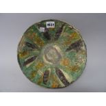 A Nishapur pottery sgraffito bowl, 12th century, decorated with radiating panels washed in green,