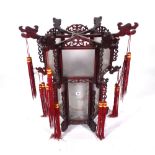 A modern Chinese hanging lantern with carved hardwood octagonal frame,