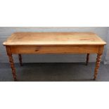 A 19th century French fruitwood plank top kitchen table, with end frieze drawer on turned supports,