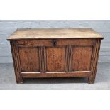 A 17th century oak coffer, the plank top over triple panel front on stile feet,