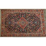 A Bidjar rug, Persian, the dark indigo floral field with a bold madder and ivory medallion,