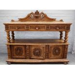 A Continental carved oak buffet, with pair of drawers over cupboards on barley-twist supports,