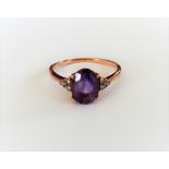 A gold, amethyst and diamond ring, claw set with the oval cut amethyst to the centre,