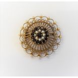 A 9ct gold, garnet and cultured pearl pendant brooch, in a shaped circular wirework design,