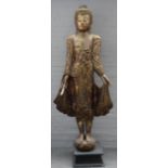 A modern Asian giltwood Budha figure on an ebonised wooden plinth, 225cm high.