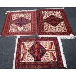 Three Baluchistan mats, each with indigo diamond filled with peacocks, other birds and flowers,