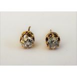 A pair of gold and diamond set single stone earstuds, each claw set with a cushion shaped diamond,