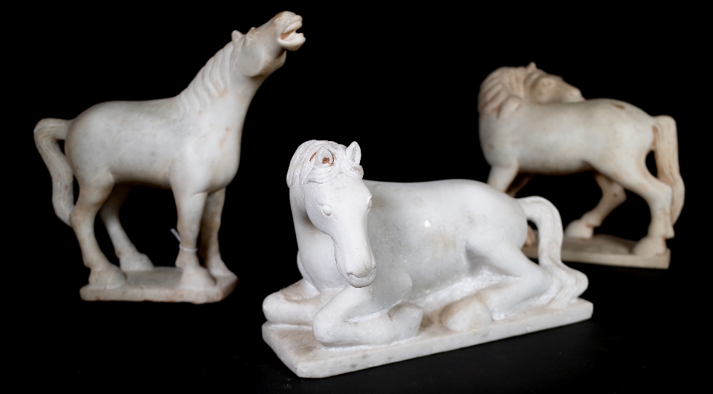 A group of four 20th century white marble Asian style models of horses in varying poses,