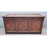 A 17th century inlaid oak coffer with triple panel lid and front on stile feet,