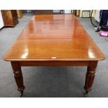 An early Victorian mahogany extending dining table on reeded supports with two extra leaves,