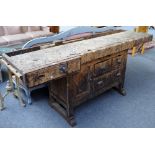 A 20th century beech and pine work bench, in distressed condition,