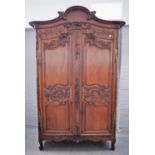 An 18th century Continental carved oak armoire, the bonnet cornice carved with birds,