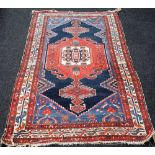 A Malayer rug, Persian, the plain indigo field with a bold madder medallion, pale indigo spandrels,