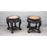 A near pair of early 20th century Chinese carved jardiniere stands with inset marble tops on paw