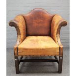 A George II style brown leather upholstered low hump back armchair with outswept arms and block