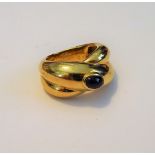 A Cartier gold and cabochon sapphire single stone ring, in a twistover design,